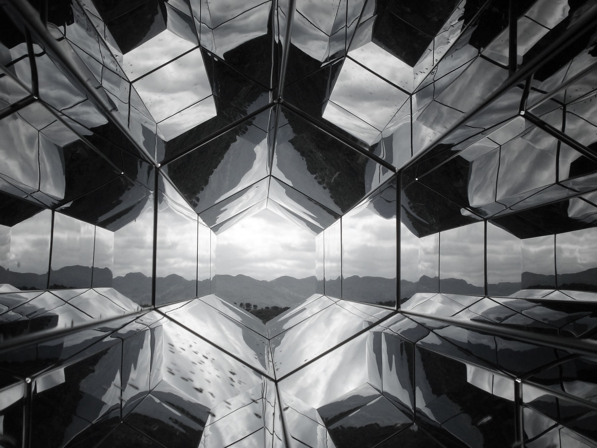 Mirrored surfaces reflect on each other to show mountain view